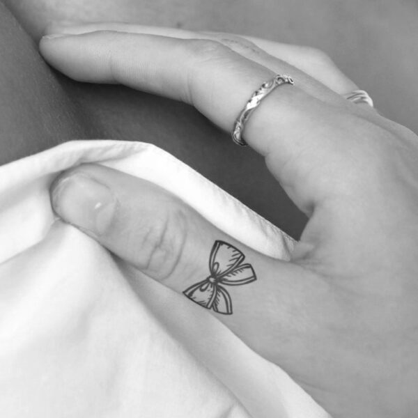 tiny bow tie semi-permanent tattoo on thumb, removable halal black jagua henna tattoo