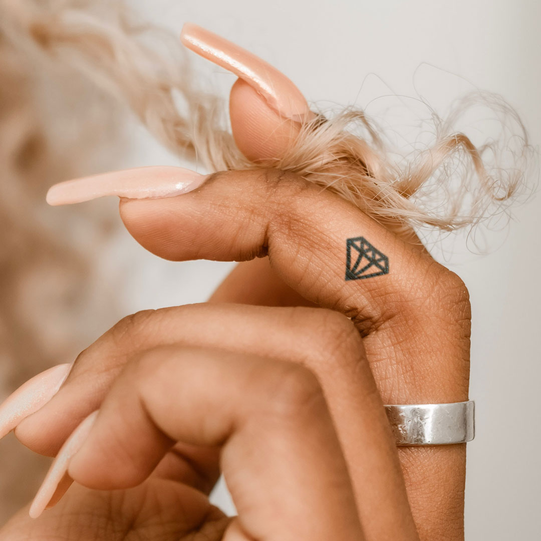 Mean symbol tattoo located on the wrist, minimalistic